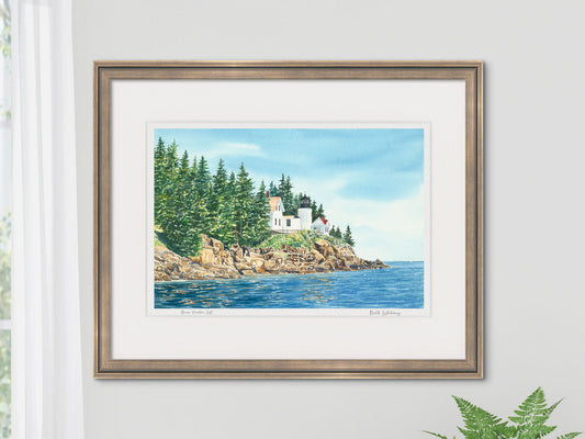 Framed watercolor print of Bass Harbor Light Left in a neutral darker frame on a white wall.