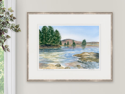 Framed watercolor print of Blue Hill Harbor Winter in a warm wood frame, styled with botanical greenery.