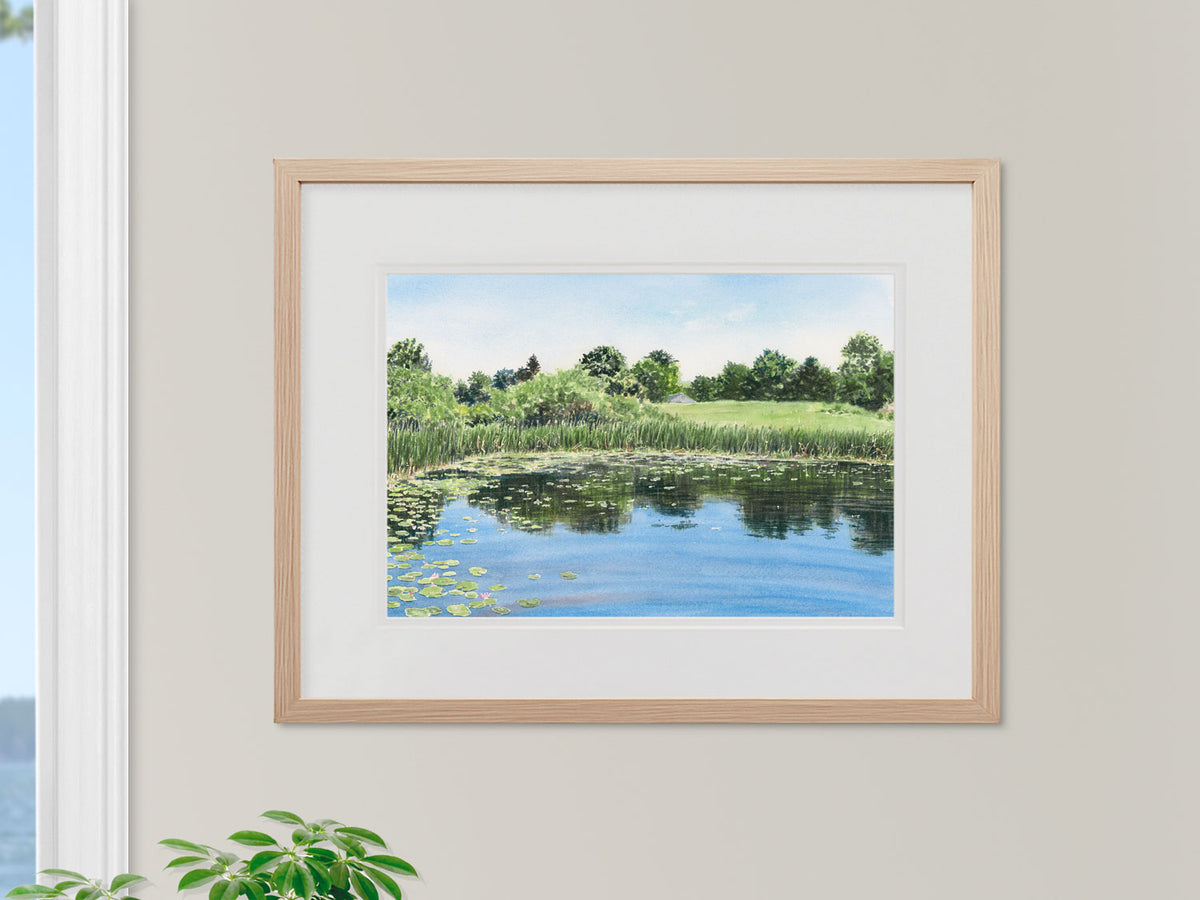 Framed original watercolor painting of Gilsland Farm Pond in a warm wood frame.