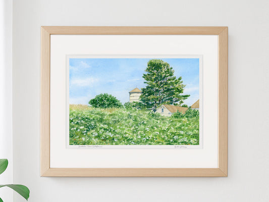 Framed watercolor print of Laudholm Farm Wildflowers, Wells, Maine, in a warm wood frame on a neutral wall.