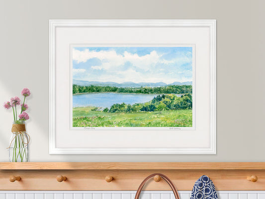 Framed watercolor print of Morgan Bay, Surry, Maine, in a white frame over a coastal inspired entryway decor.
