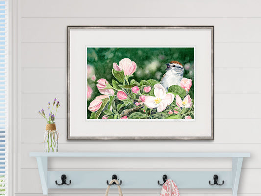 Framed watercolor print of Ode to Spring, chipping sparrow in apple tree, in a pewter frame in a coastal entryway decor.