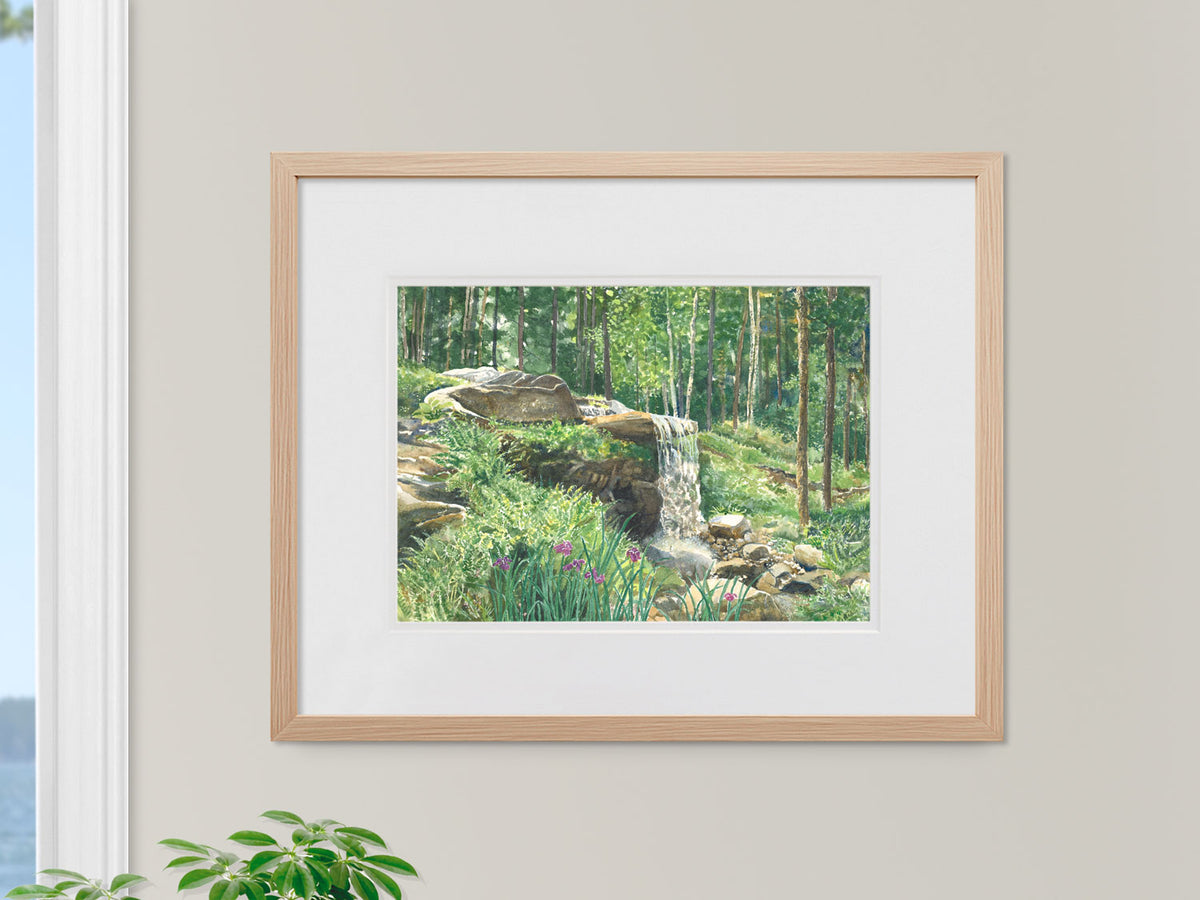 Framed original watercolor painting of Woodland Waterfall, Coastal Maine Botanical Gardens, Boothbay, in a warm wood frame in a window setting.