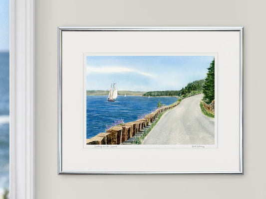 Framed watercolor print of Sailing on the Sound, Mount Desert Island, in a silver frame in a coastal window setting.