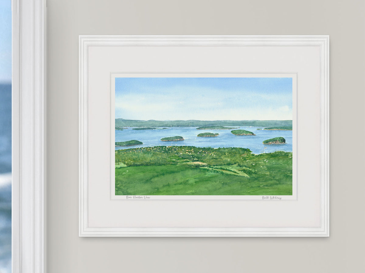 Framed watercolor print of Bar Harbor View from Cadillac Mountain, Acadia, in a white frame with natural window light.