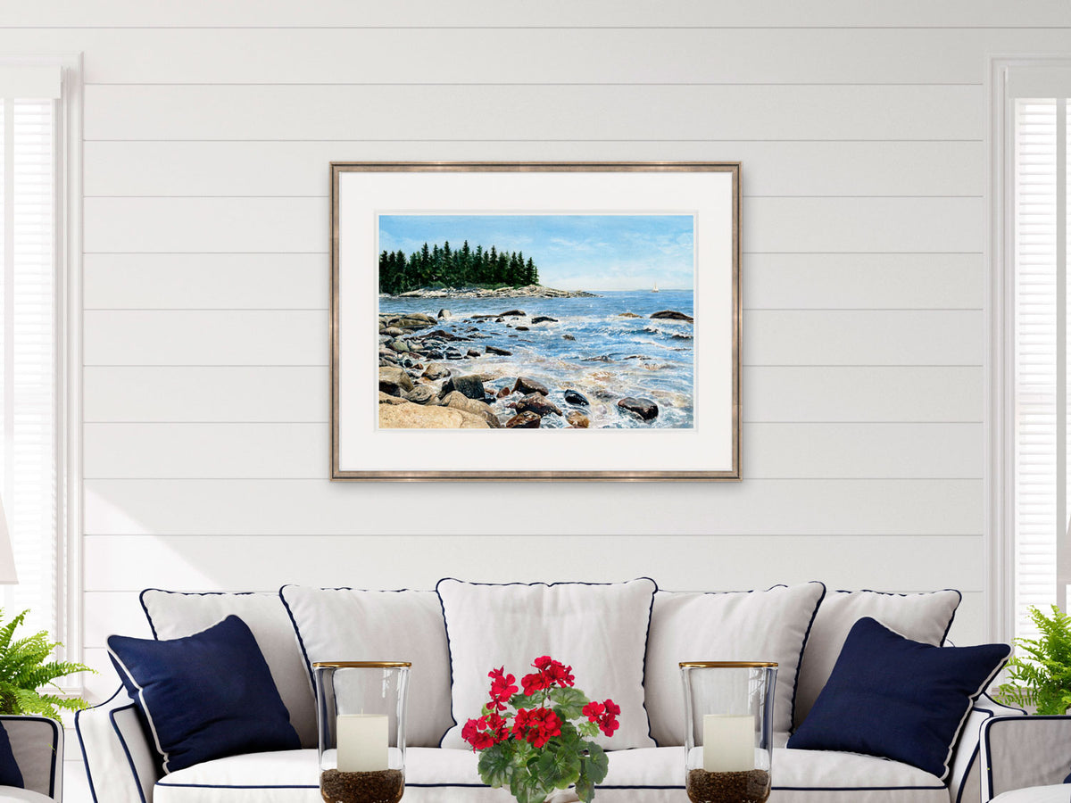 Framed watercolor print of Barred Island, Deer Isle, styled in a living room with navy accents.