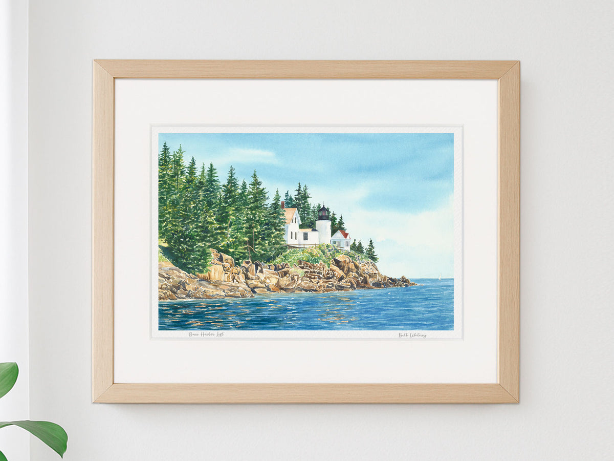 Framed watercolor print of Bass Harbor Light Left in a neutral darker frame on a white wall.