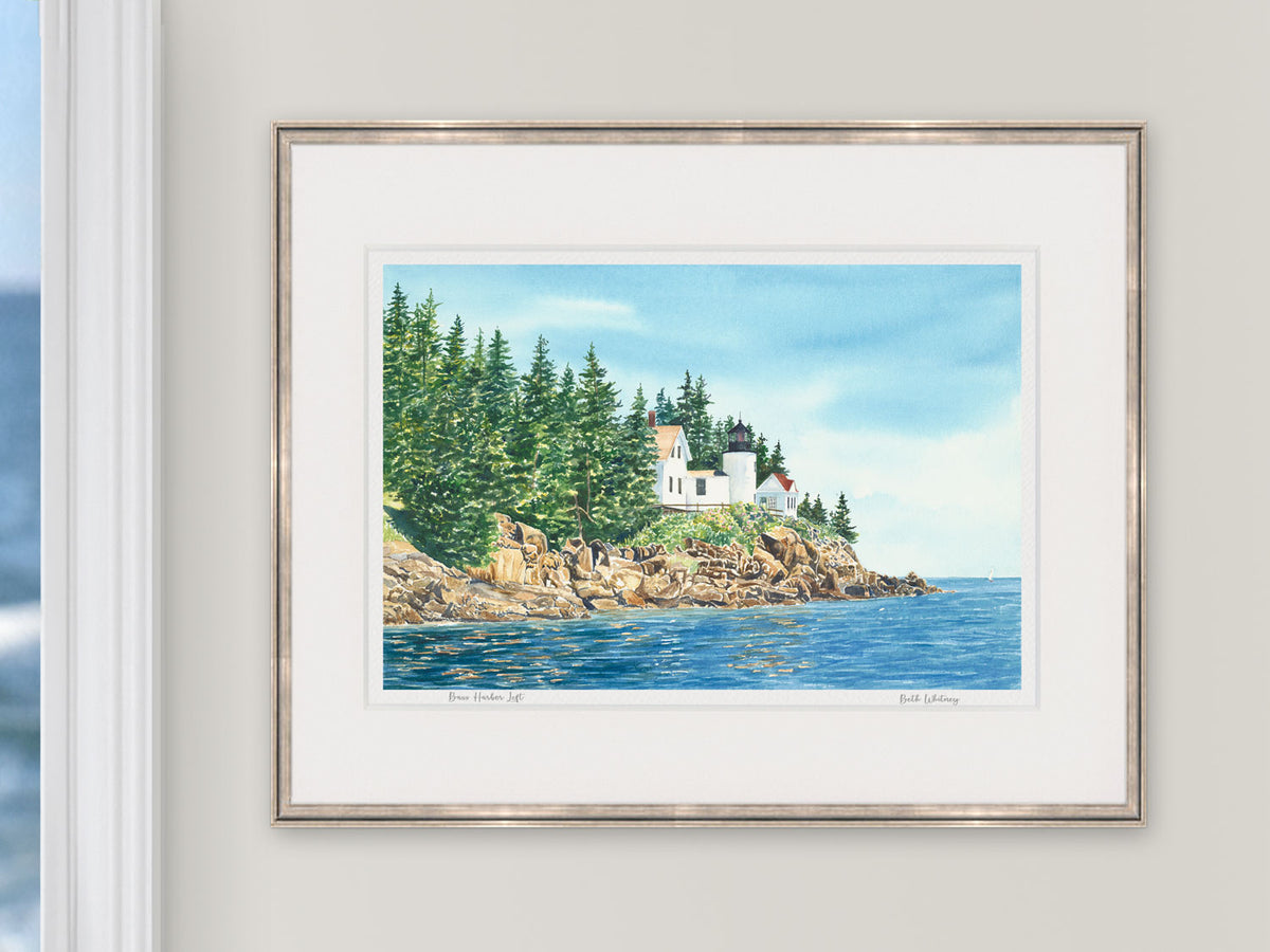 Framed watercolor print of Bass Harbor Light Left, Acadia National Park, in a white frame with natural window light.