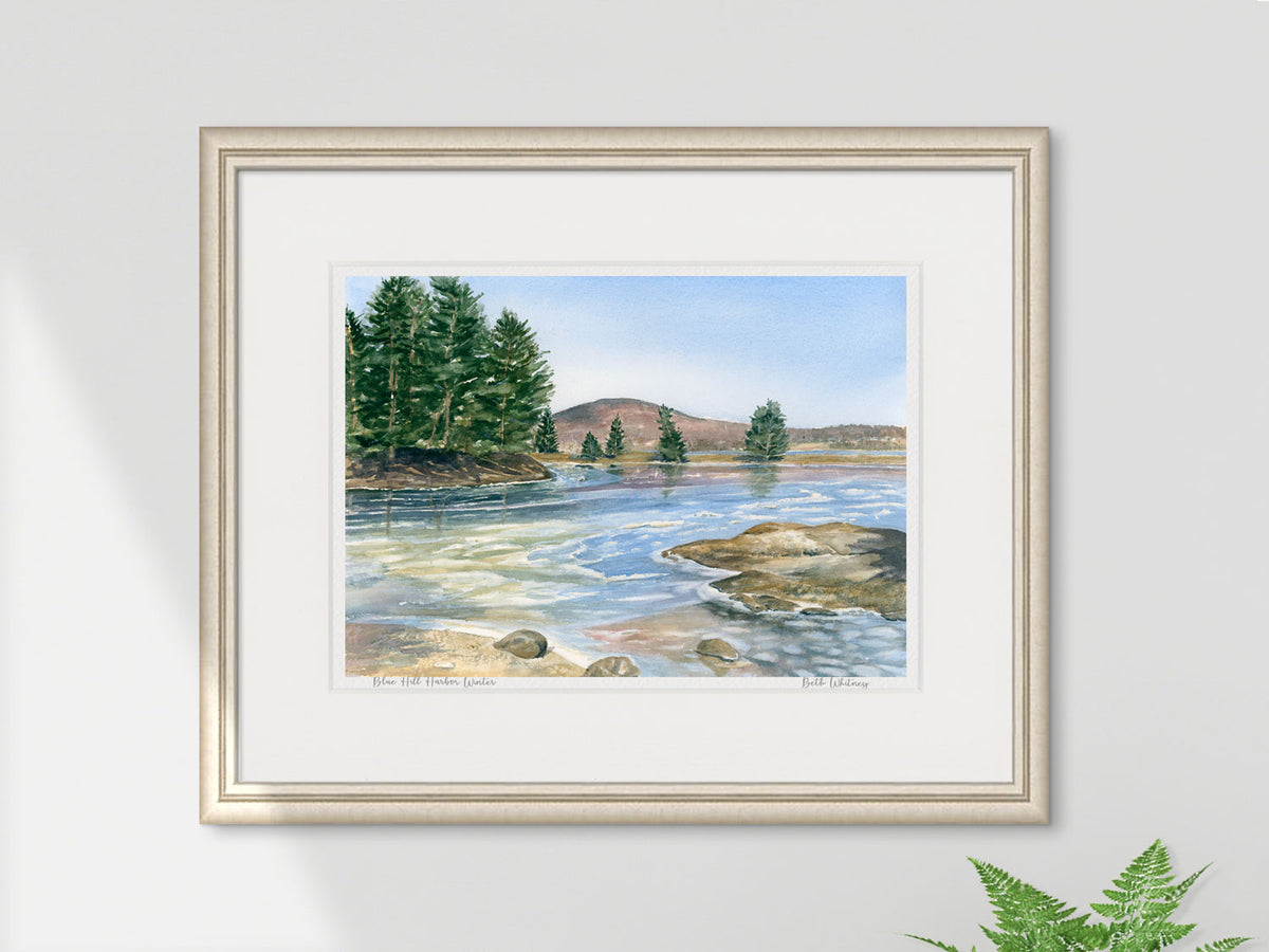 Framed watercolor print of Blue Hill Harbor Winter in a pale gold frame on a neutral wall.