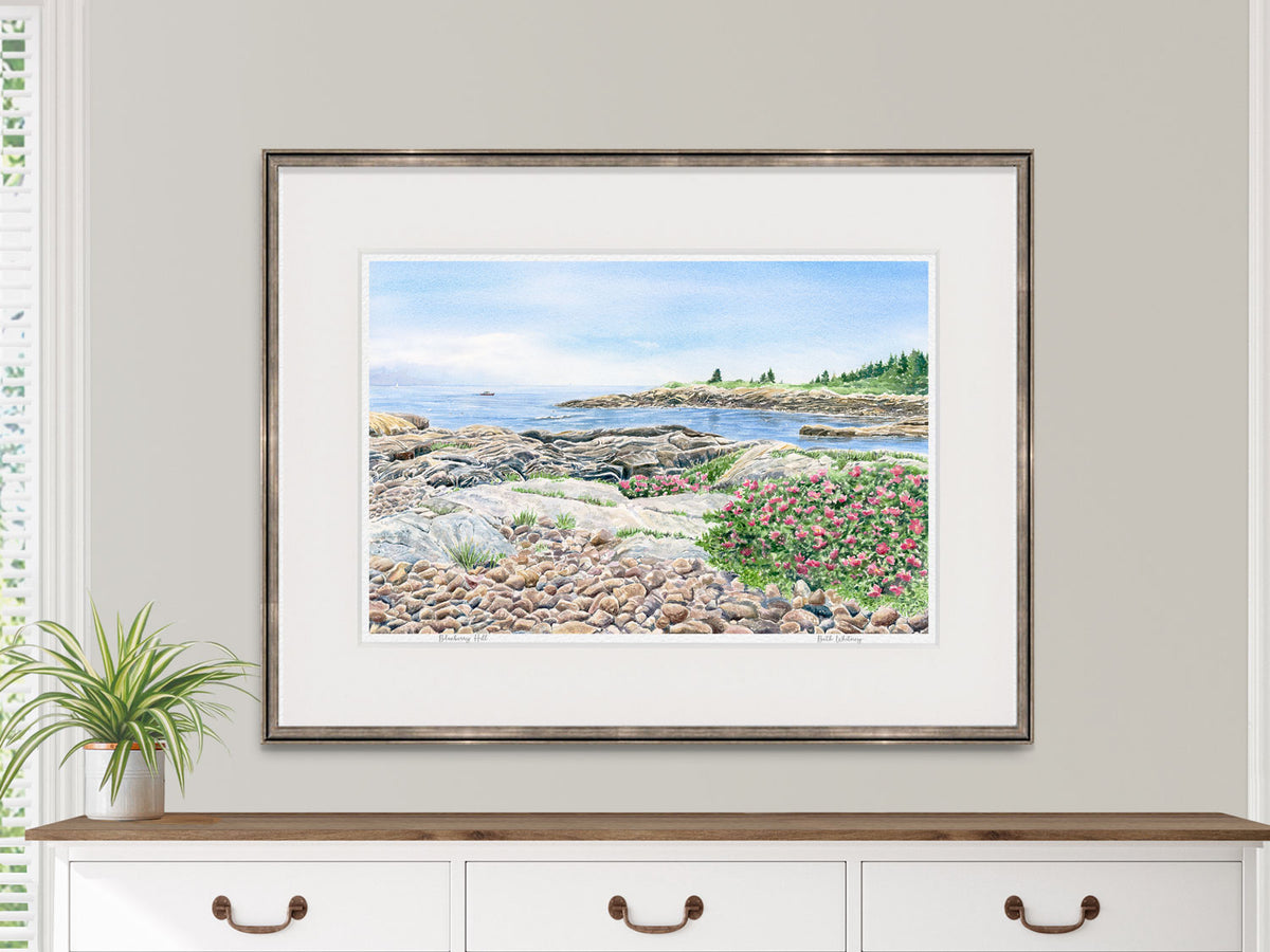 Framed watercolor print of Blueberry Hill, Acadia National Park, displayed above a dresser in a lifestyle setting.