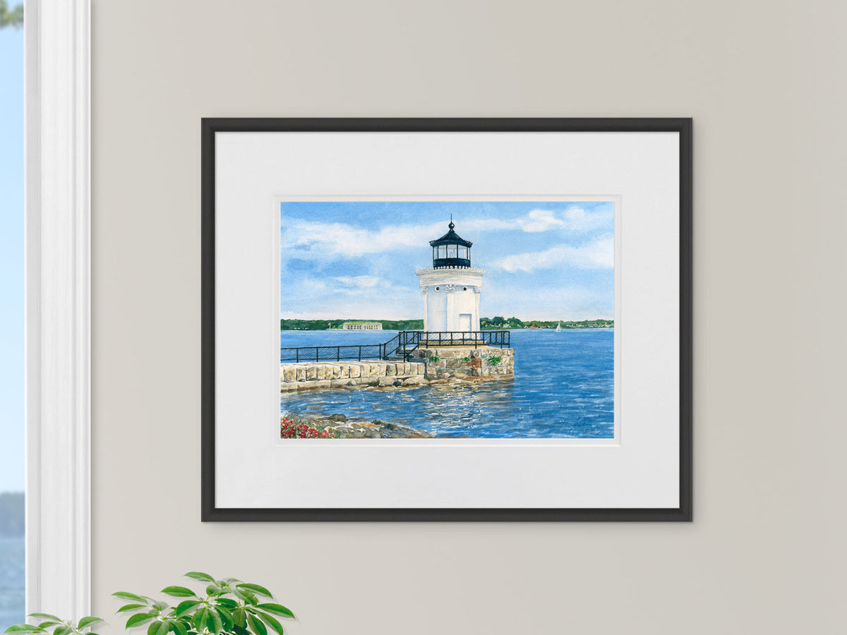 Framed original watercolor painting of Bug Light, South Portland, in a warm wood frame in an interior setting.