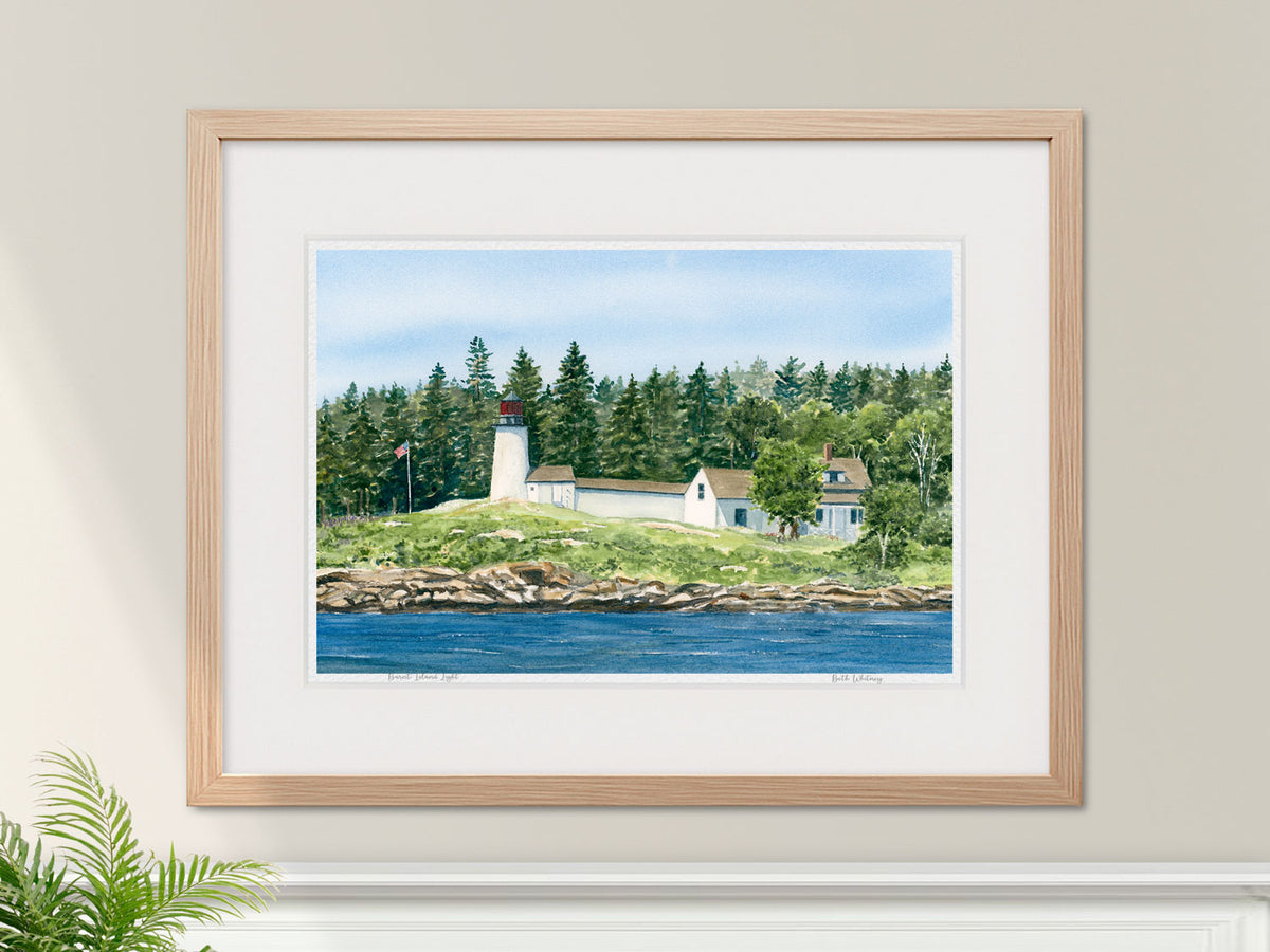 Framed watercolor print of Burnt Island Light in a warm wood frame with botanical styling.