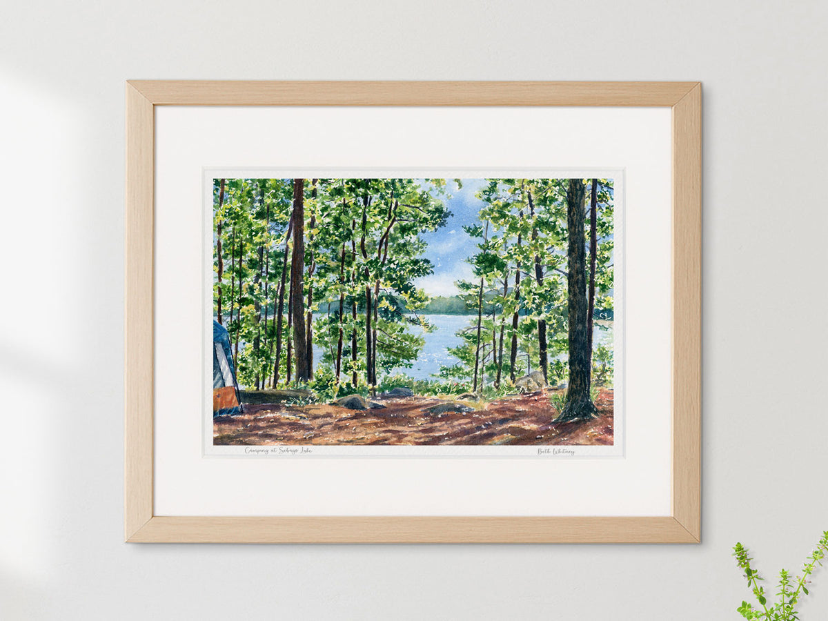 Framed watercolor print of Camping at Sebago Lake in a warm wood frame on a neutral wall.