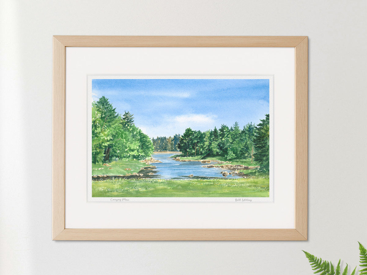 Framed watercolor print of Carrying Place, Downeast Maine, in a warm wood frame on a neutral wall.