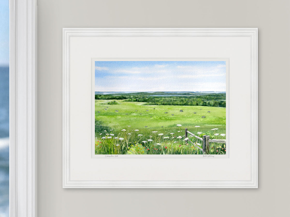Framed watercolor print of Caterpillar Hill, Eggemoggin Reach view, in a white frame with natural window light.