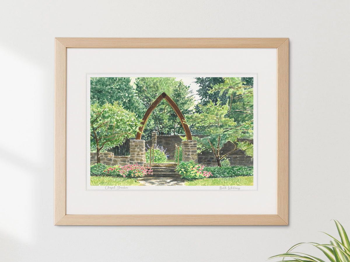 Framed watercolor print of Chapel Garden, Vesper Hill, Rockport, Maine, in a warm wood frame on a neutral wall.