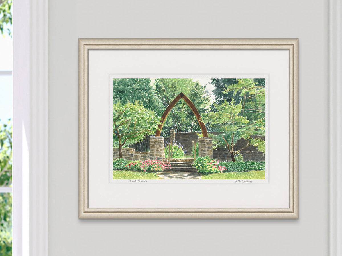 Framed watercolor print of Chapel Garden, Rockport, Maine, in a pale gold frame on a neutral wall.