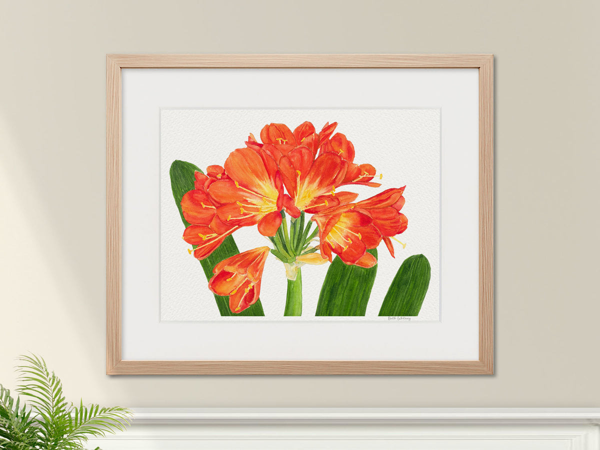 Framed watercolor print of Clivia in a warm wood frame with botanical styling.