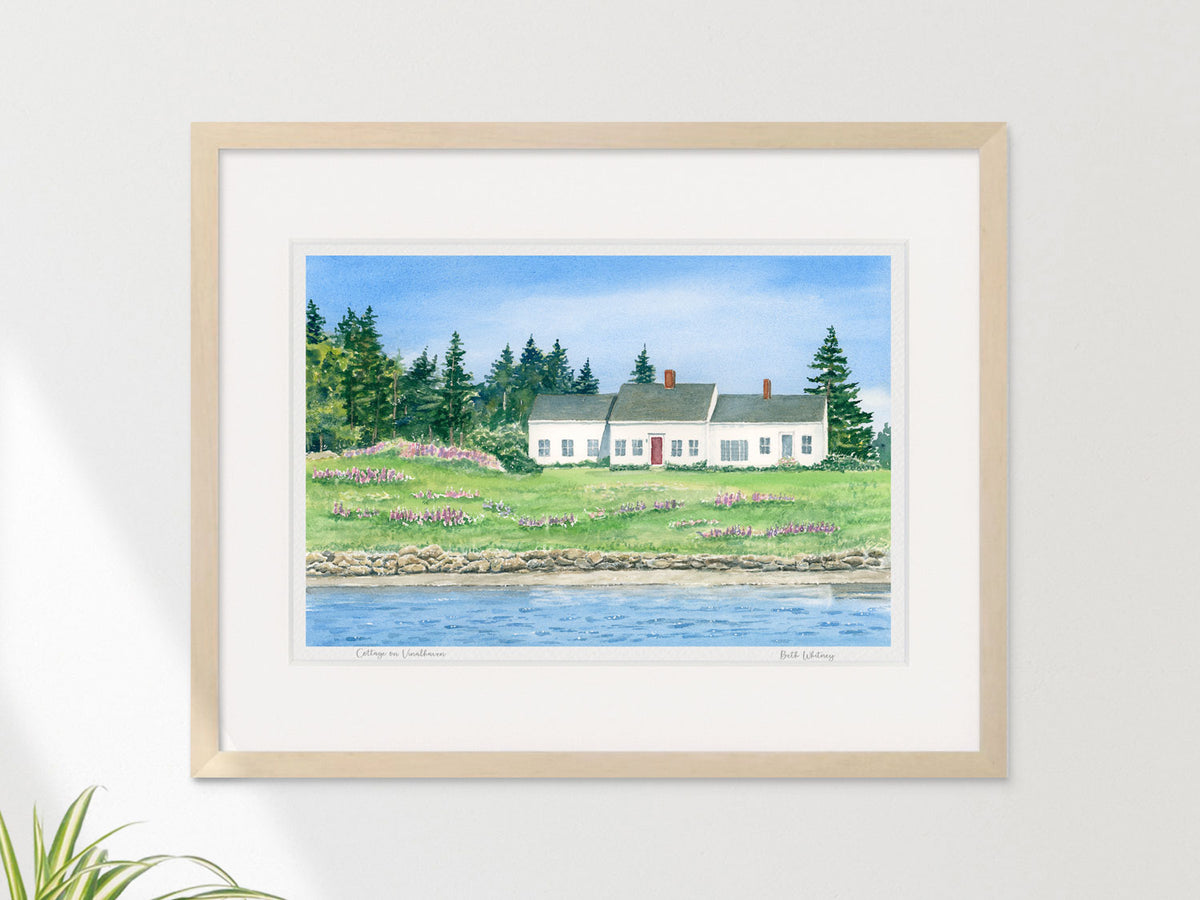 Framed watercolor print of Cottage on Vinalhaven in a warm wood frame on a neutral wall.