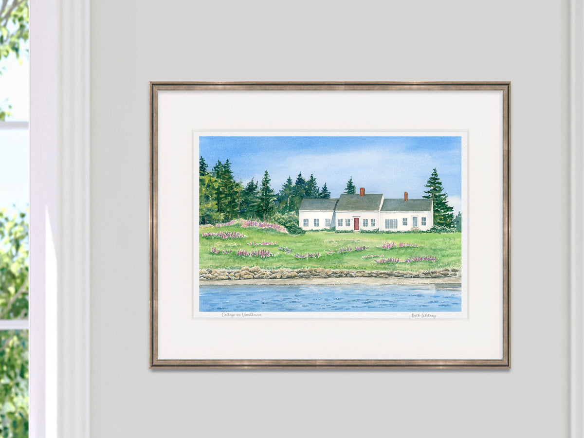 Framed watercolor print of Cottage on Vinalhaven in a silver frame on a neutral wall.