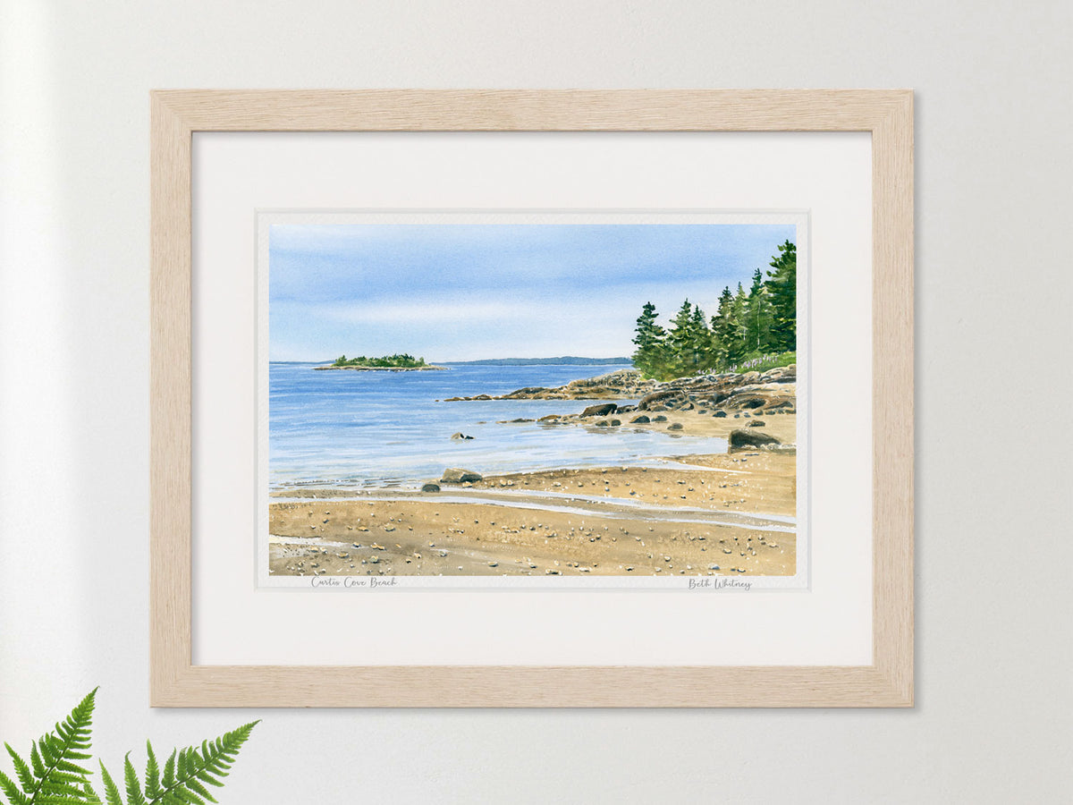 Framed watercolor print of Curtis Cove Beach, East Blue Hill, Maine, in a warm wood frame with fern styling.