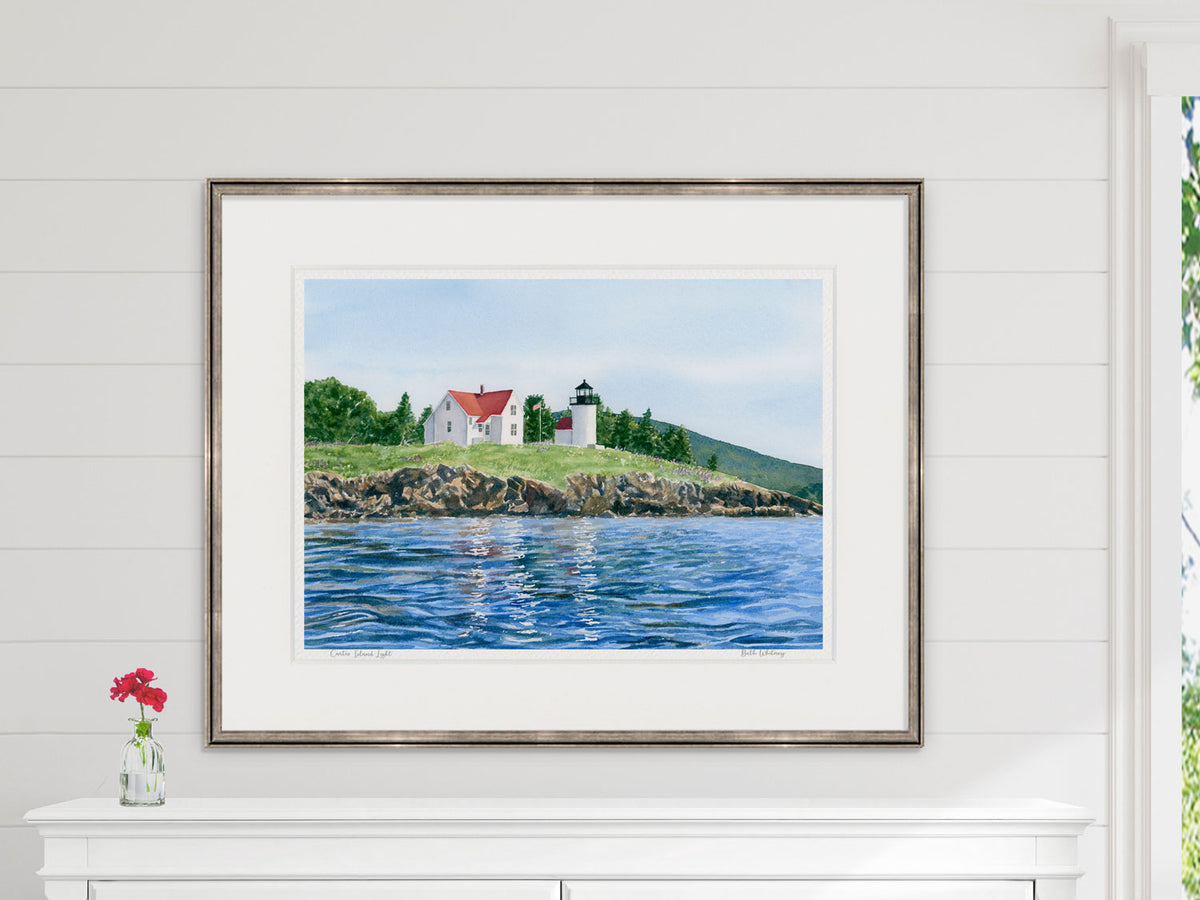 Framed watercolor print of Curtis Island Light, Camden, Maine, in a white frame with natural window light.