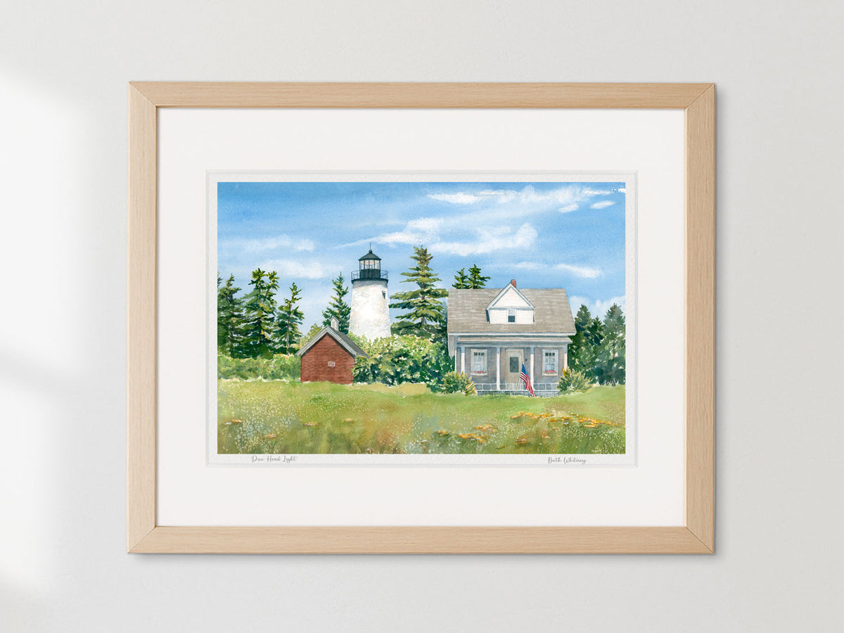 Framed watercolor print of Dice Head Light, Castine, Maine, in a warm wood frame on a neutral wall.