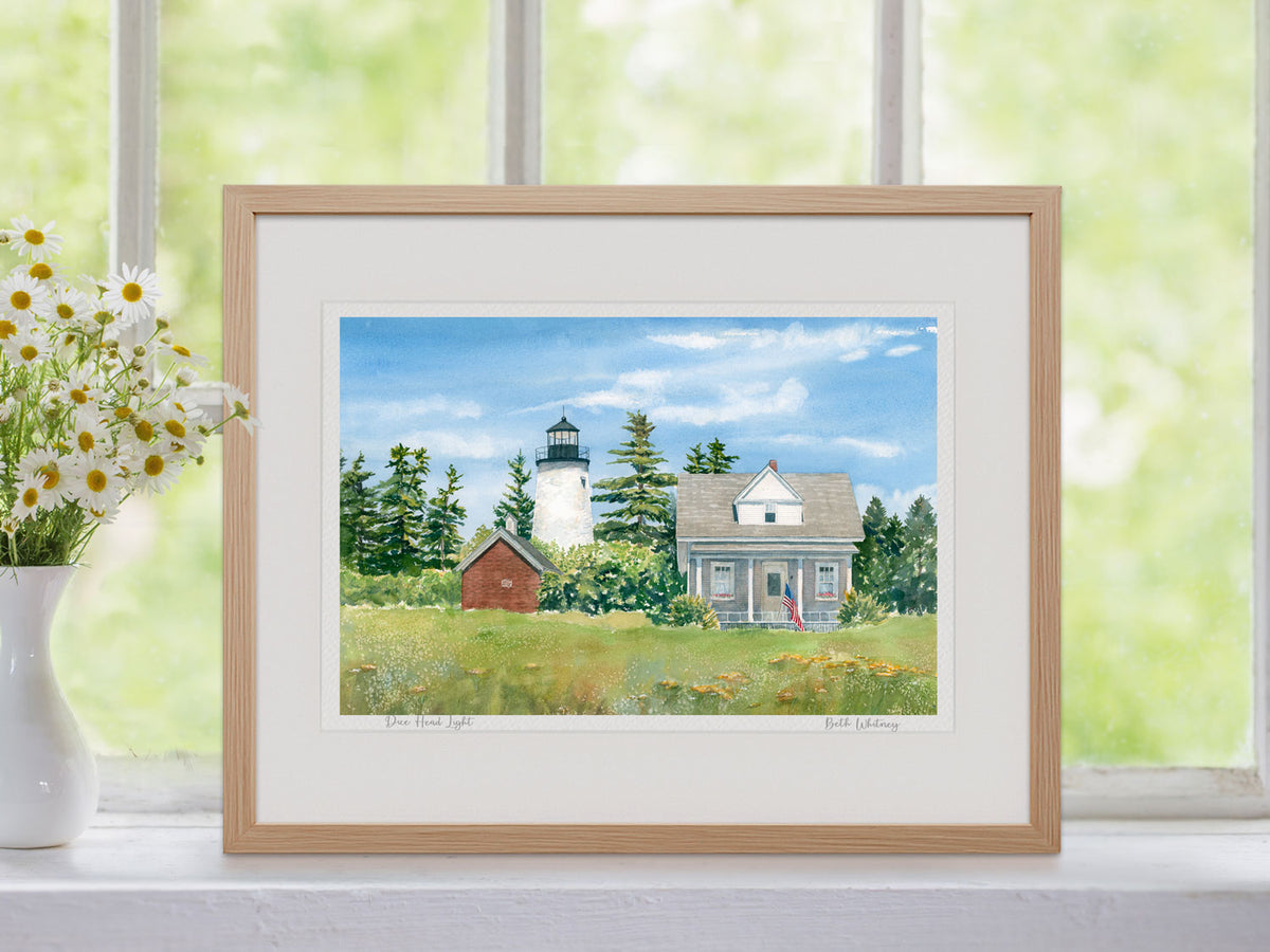 Framed watercolor print of Dice Head Light in a warm wood frame with botanical styling.