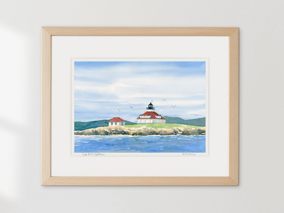 Framed watercolor print of Egg Rock Lighthouse, Frenchman's Bay, in a warm wood frame on a neutral wall.