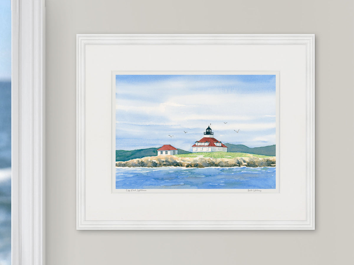 Framed watercolor print of Egg Rock Lighthouse, Bar Harbor, Maine, in a white frame with natural window light.