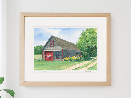 Framed watercolor print of Friendship Barn, Friendship, Maine, in a warm wood frame on a neutral wall.
