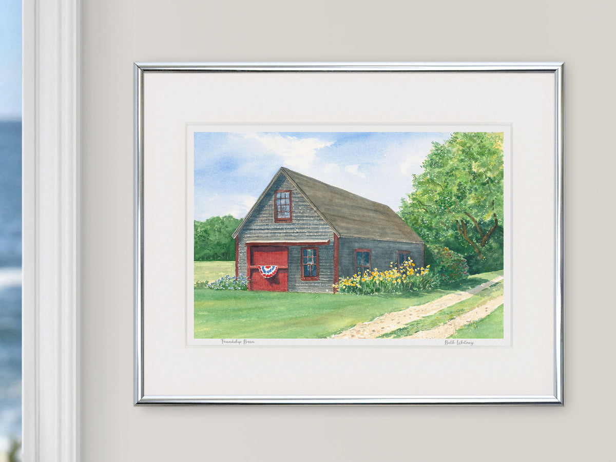 Framed watercolor print of Friendship Barn in a silver frame with natural window light.