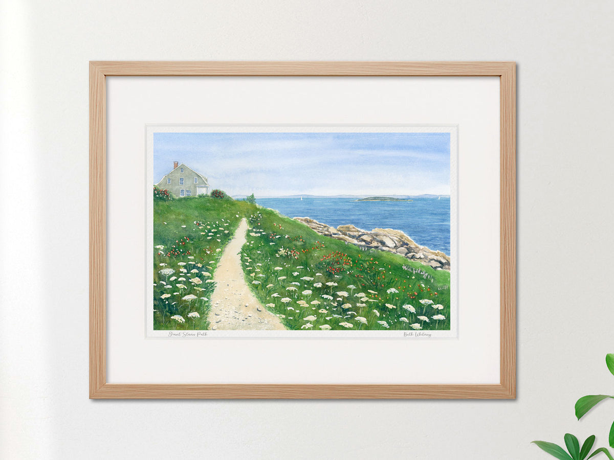 Framed watercolor print of Giant Stairs Path, Bailey Island, in a warm wood frame on a neutral wall.