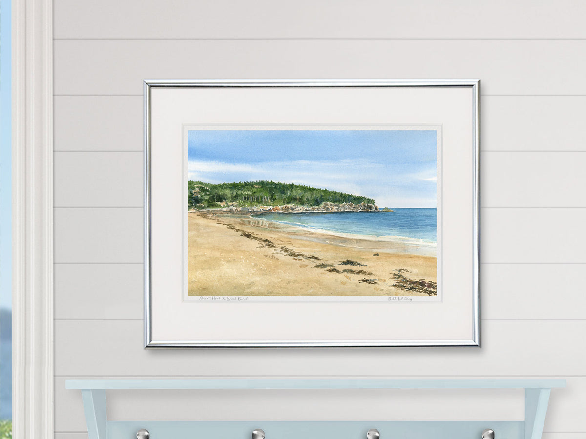 Framed watercolor print of Great Head, Acadia National Park, in a white frame on a shiplap wall.