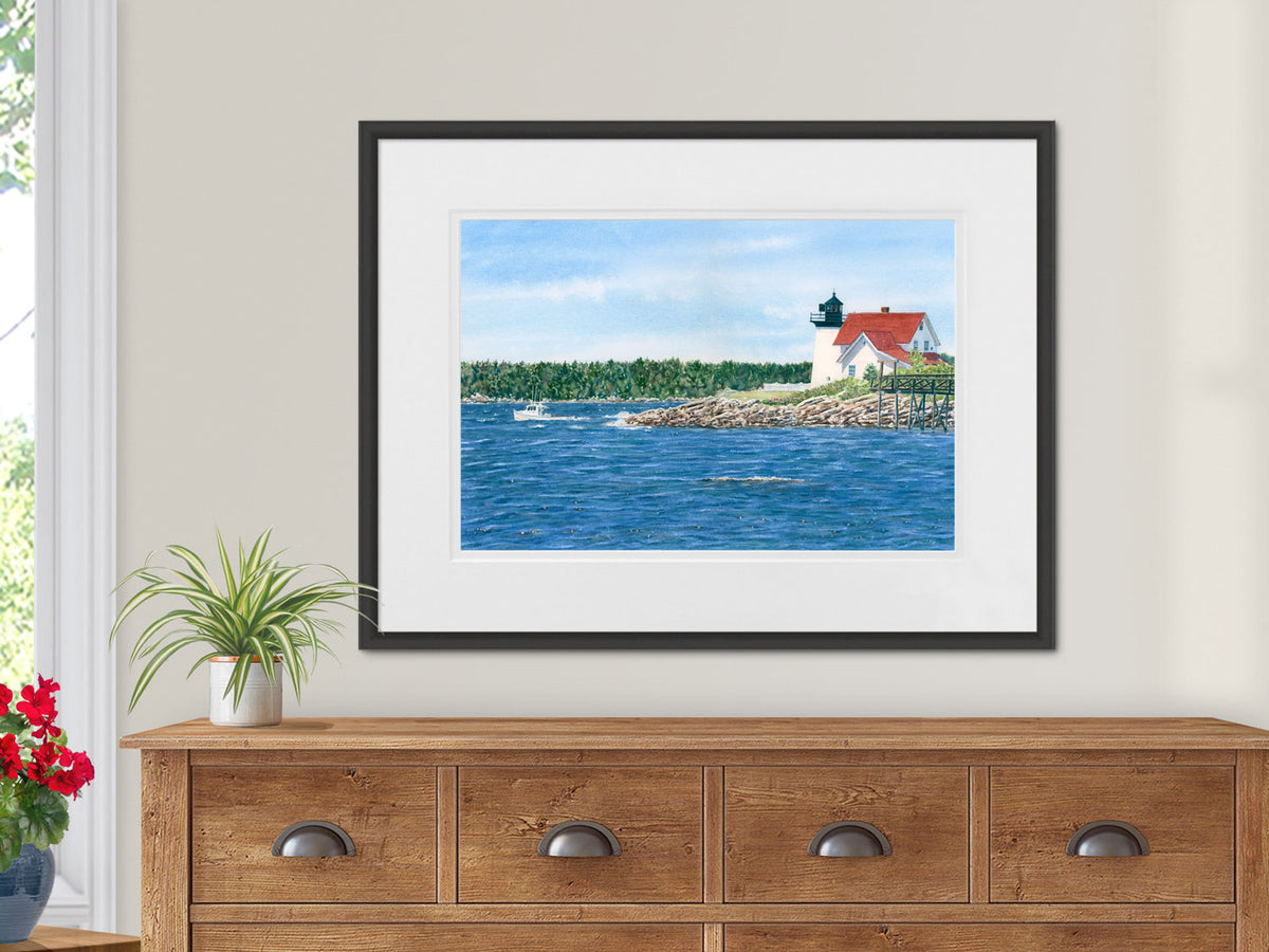 Watercolor painting of Hendricks Head Lighthouse near Boothbay Harbor, Maine shown over a wooden buffet.