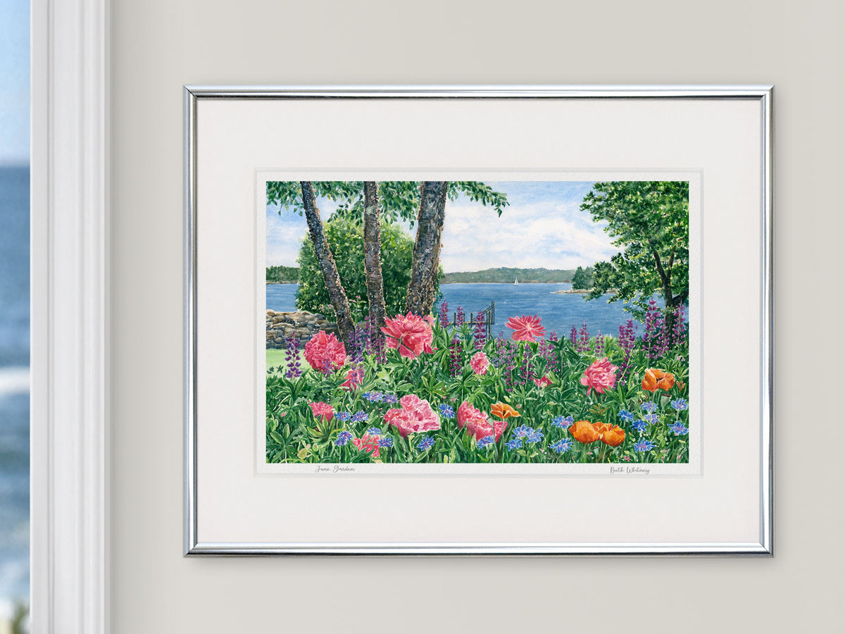 Framed watercolor print of June Garden, coastal Maine, in a silver frame with natural window light.