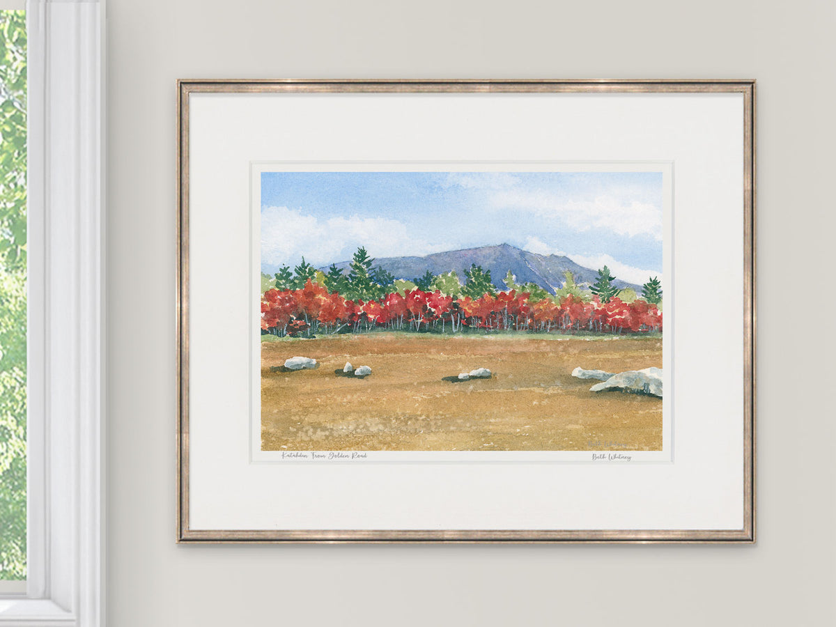 Framed watercolor print of Katahdin From the Golden Road, Maine, in a light gold frame with natural window light.