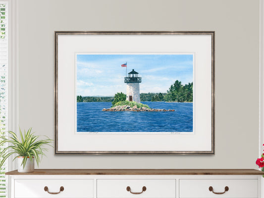 Framed watercolor print of Ladies Delight Light in a warm wood frame over a white sideboard in a lifestyle setting.