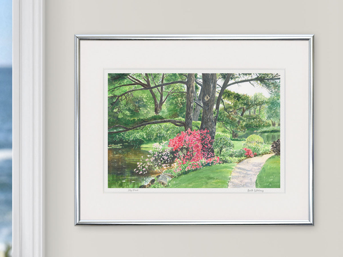 Framed watercolor print of Lily Pond, Northeast Harbor, Maine, in a silver frame in a coastal window setting.