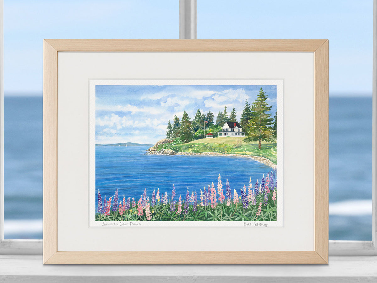 Framed watercolor print of Lupine on Cape Rosier, Cape Rosier, Maine, in a warm wood frame in a coastal window setting.