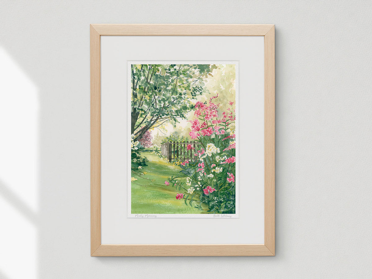 Framed watercolor print of Misty Morning, country garden near Blue Hill, Maine, in a natural wood frame on a neutral wall.