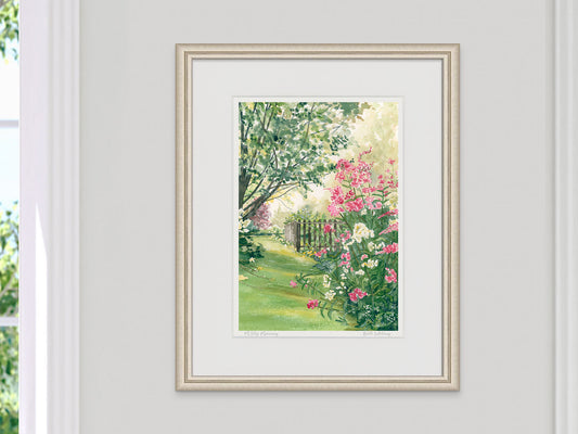 Framed watercolor print of Misty Morning, Maine country garden, in a pale gold frame on a neutral bedroom wall.