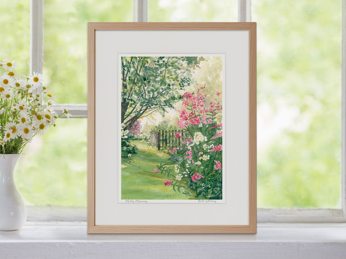 Framed watercolor print of Misty Morning, Blue Hill, Maine, in a warm wood frame on a windowsill decor beside a bouquet of flowers.