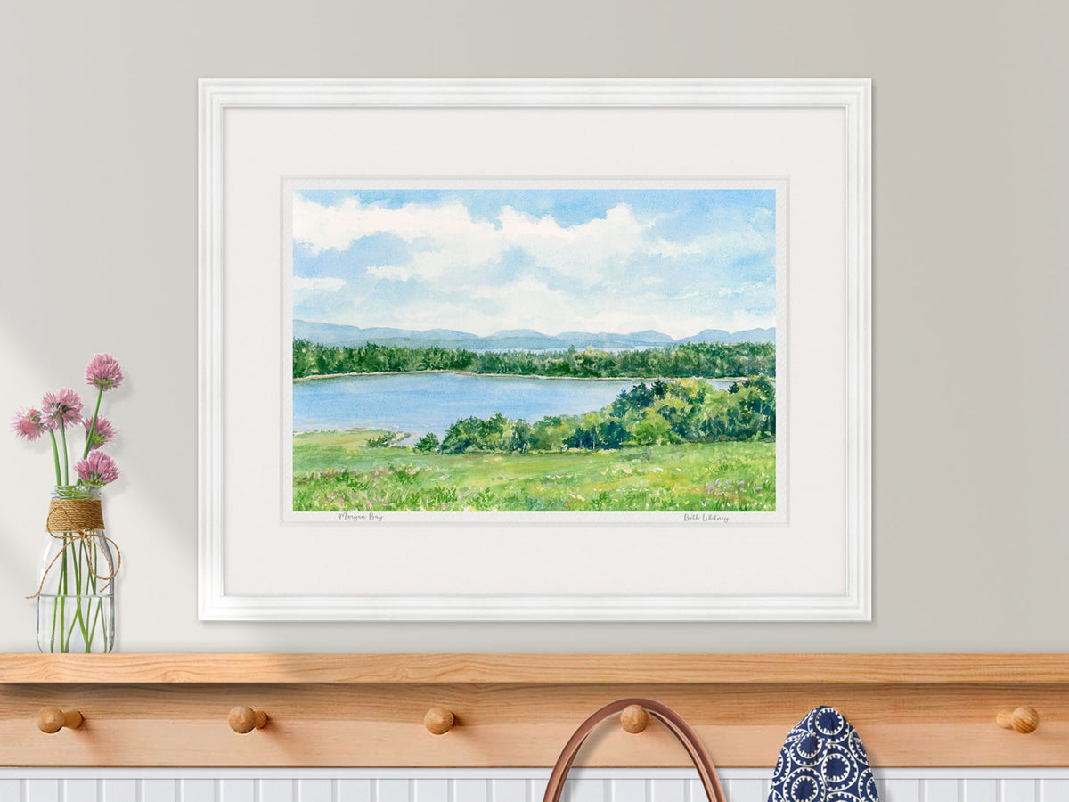 Framed watercolor print of Morgan Bay, Surry, Maine, in a white frame over a coastal inspired entryway decor.