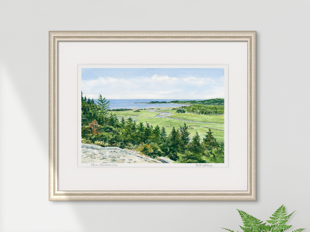 Framed watercolor print of Morse Mountain View, Phippsburg, Maine, in a pale gold frame on a neutral wall with a fern.