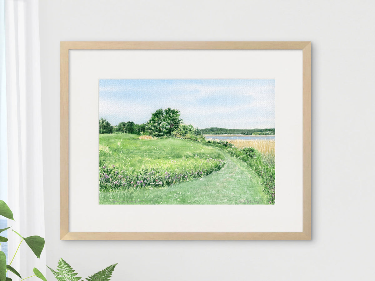 Framed original watercolor painting of North Meadow, Gilsland Farm, Falmouth, Maine, in a warm wood frame with houseplants.