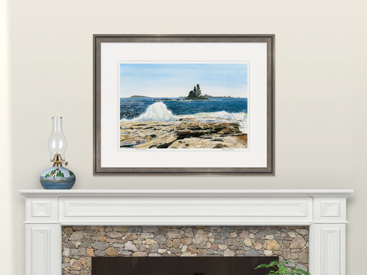 Framed watercolor print of Ocean Point, East Boothbay, Maine, in a dark frame above a fireplace mantel with a lighthouse hurricane lamp.