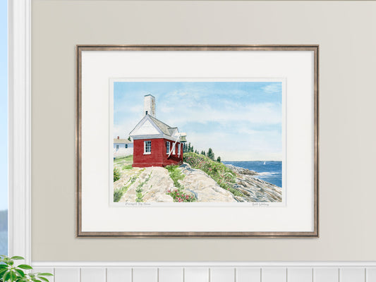 Framed watercolor print of Pemaquid Fog House, Pemaquid Point, Maine, in a warm wood frame in a coastal home decor lifestyle setting.