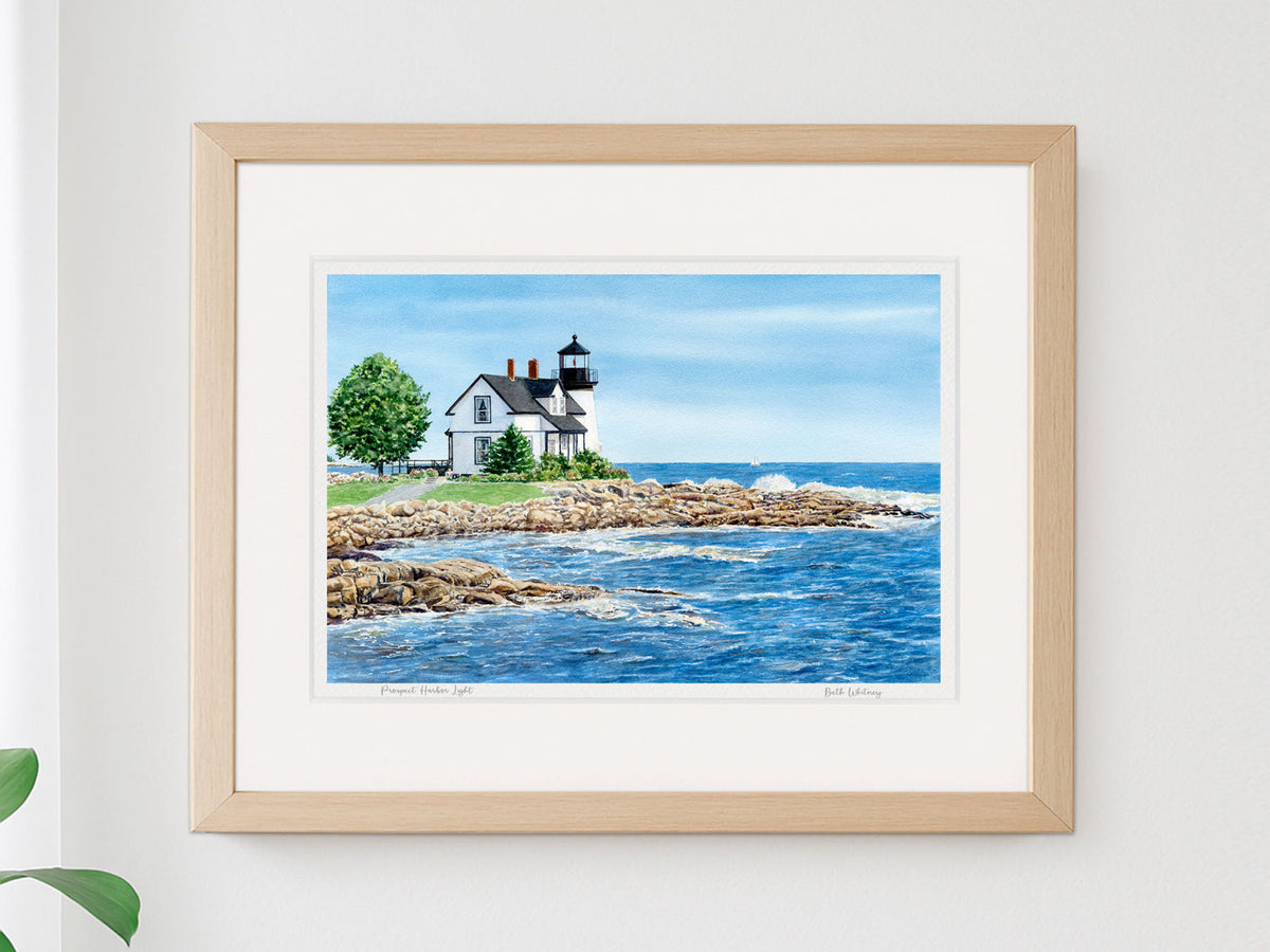 Framed watercolor print of Prospect Harbor Light, Gouldsboro, Maine, in a warm wood frame on a neutral wall.
