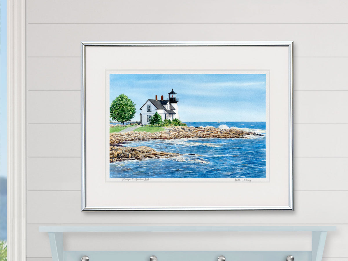 Framed watercolor print of Prospect Harbor Light, Gouldsboro, Maine, in a silver frame on a ship lap wall in a coastal home decor.